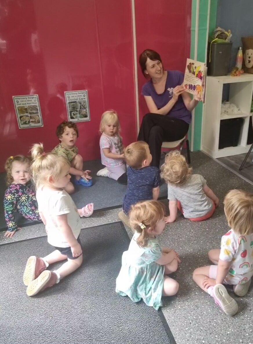 Stacey, a member of staff, reading a story to a group of children